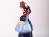 a figurine of a woman sitting on top of a table