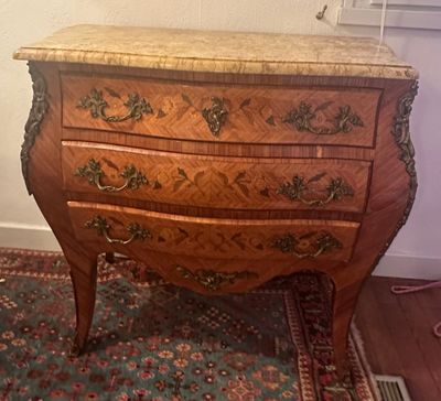 une commode en bois sur un tapis dans une pièce
