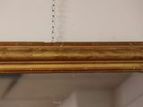 an antique gold framed mirror with a chain hanging from it ' s side