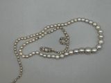 gros plan d'un collier de perles sur une surface blanche
