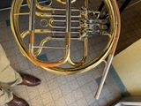 a man standing next to a brass instrument in a room