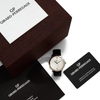 a black and white watch and business card on a table