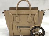 the small beige handbag is next to a leash on a marble surface