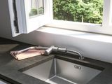 a sink in the corner of a kitchen next to a window