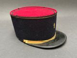 un chapeau noir orné d'un ruban rouge sur le dessus
