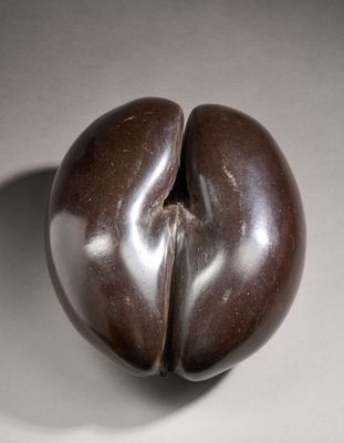 a chocolate sculpture of an apple on a white surface