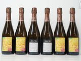 six bouteilles de vin sont alignées sur une table