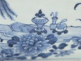 a blue and white plate with a picture of a man and a woman in a boat