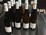 several bottles of wine are lined up on a table in a restaurant