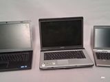 three laptops sitting side by side on a table