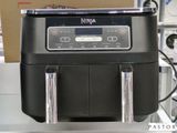 une cafetière noire posée sur le plan de travail d'une cuisine