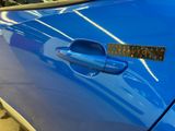 a blue car with a sticker on the door handle