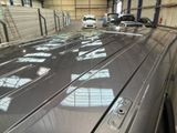 a car that is parked in a garage with other cars in the background