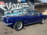 une photo d'une Mustang bleue garée devant un immeuble