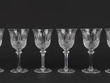 six wine glasses lined up in a row on a black surface