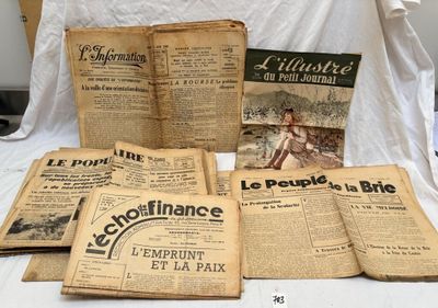 plusieurs vieux journaux posés sur un lit, à côté d'un drap blanc