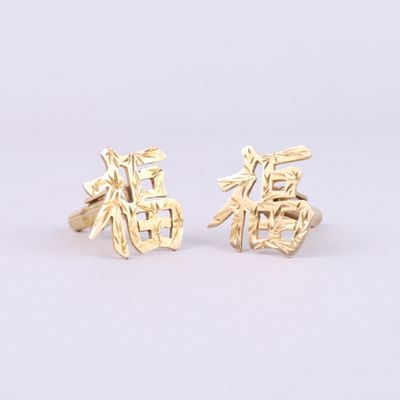 une paire de boutons de manchette en or ornés de caractères chinois