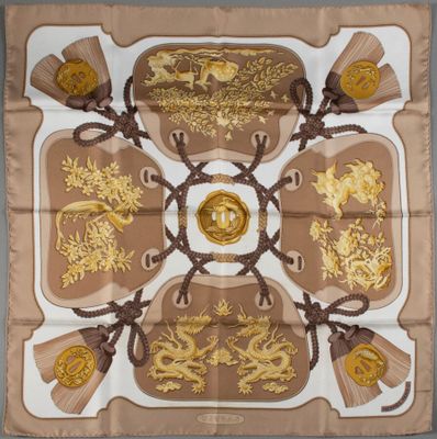 a close up of a square scarf with gold and brown designs