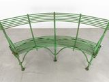a green bench that is sitting on a cement floor
