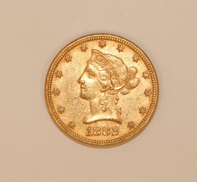 a close up of a gold coin with a woman ' s head on it