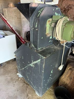une machine posée par terre à côté d'un tas de bois