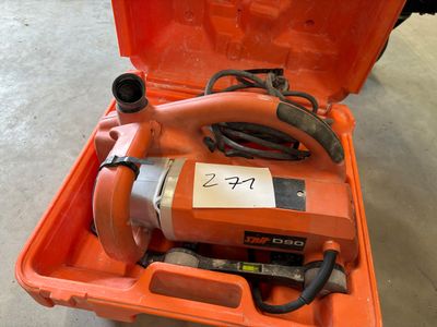 une caisse à outils orange posée par terre et contenant des outils