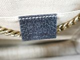 the back of a white purse with a black label on it