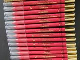 une pile de crayons de couleur rouge et or empilés les uns sur les autres