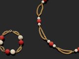 un gros plan sur un collier et un bracelet composés de perles rouges et blanches
