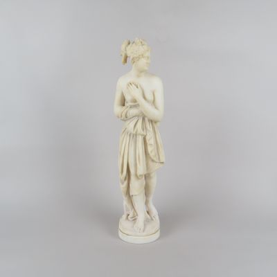 une statue ancienne représentant une femme tenant une fleur dans ses mains