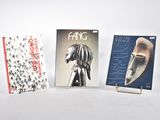 trois livres sont posés les uns à côté des autres sur une surface blanche
