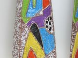 two vases with colorful designs on them on a white surface