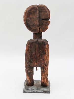 a wooden statue of a person with a head on a base
