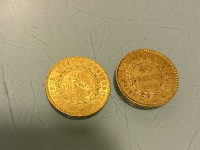 two gold coins sitting next to each other on top of a table