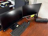 un bureau sur lequel sont posés deux écrans d'ordinateur et un clavier