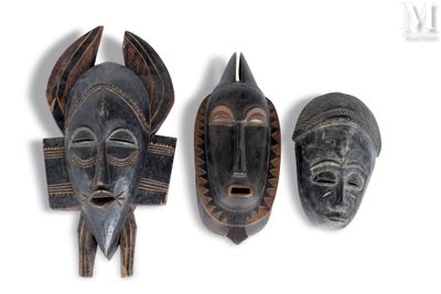 trois masques africains sont exposés sur un fond blanc