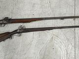 trois armes à feu sont posées par terre à côté d'une bouteille de bière
