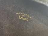 a close up of a black purse with a gold logo on it