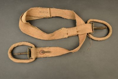 two pieces of cloth with a metal buckle on a gray surface