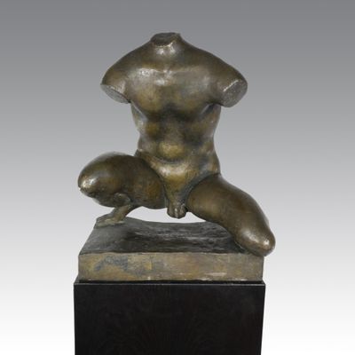 une photo d'une statue en bronze représentant une femme assise sur un bloc