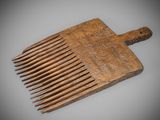 an old wooden comb is sitting on top of a gray surface