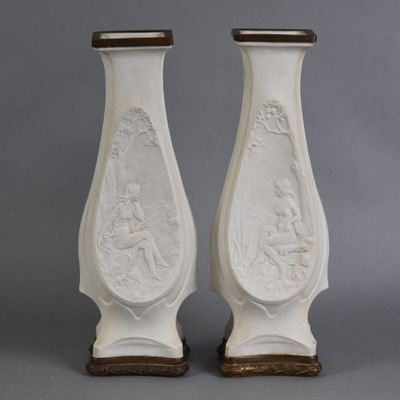 une paire de vases blancs ornés de motifs sur fond gris