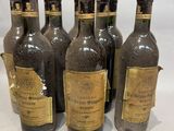 six bouteilles de vin sont alignées sur une table