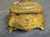 an antique brass box with a lid on a blue cloth