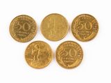 quatre pièces d'or sont disposées sur une surface blanche
