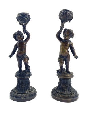 paire de figurines anciennes en bronze représentant un garçon et une fille tenant un panier