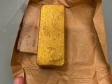 someone is holding a piece of paper with a piece of gold on it