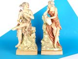 deux figurines d'un homme et d'une femme assis sur un rocher