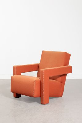 une chaise orange posée sur un sol en béton