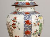a vase with a lid sitting on a wooden table